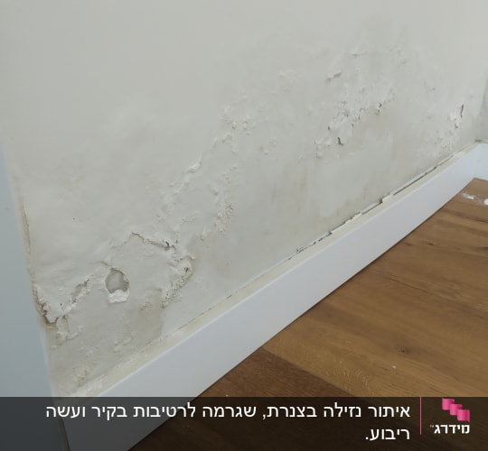 קיר עם רטיבות ונזקי מים ליד הרצפה